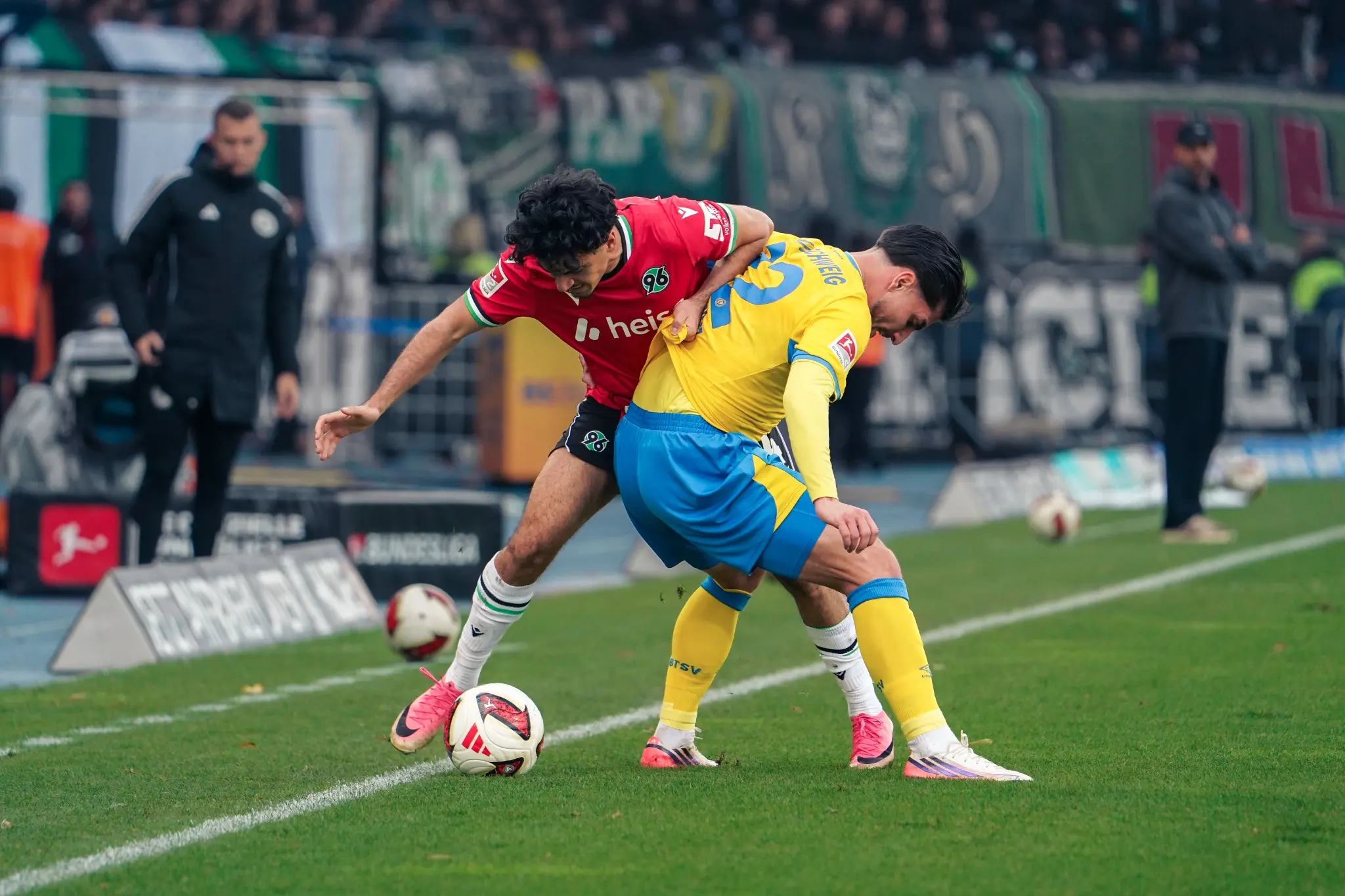 Braunschweig and Hannover players contest the ball near the touchline.