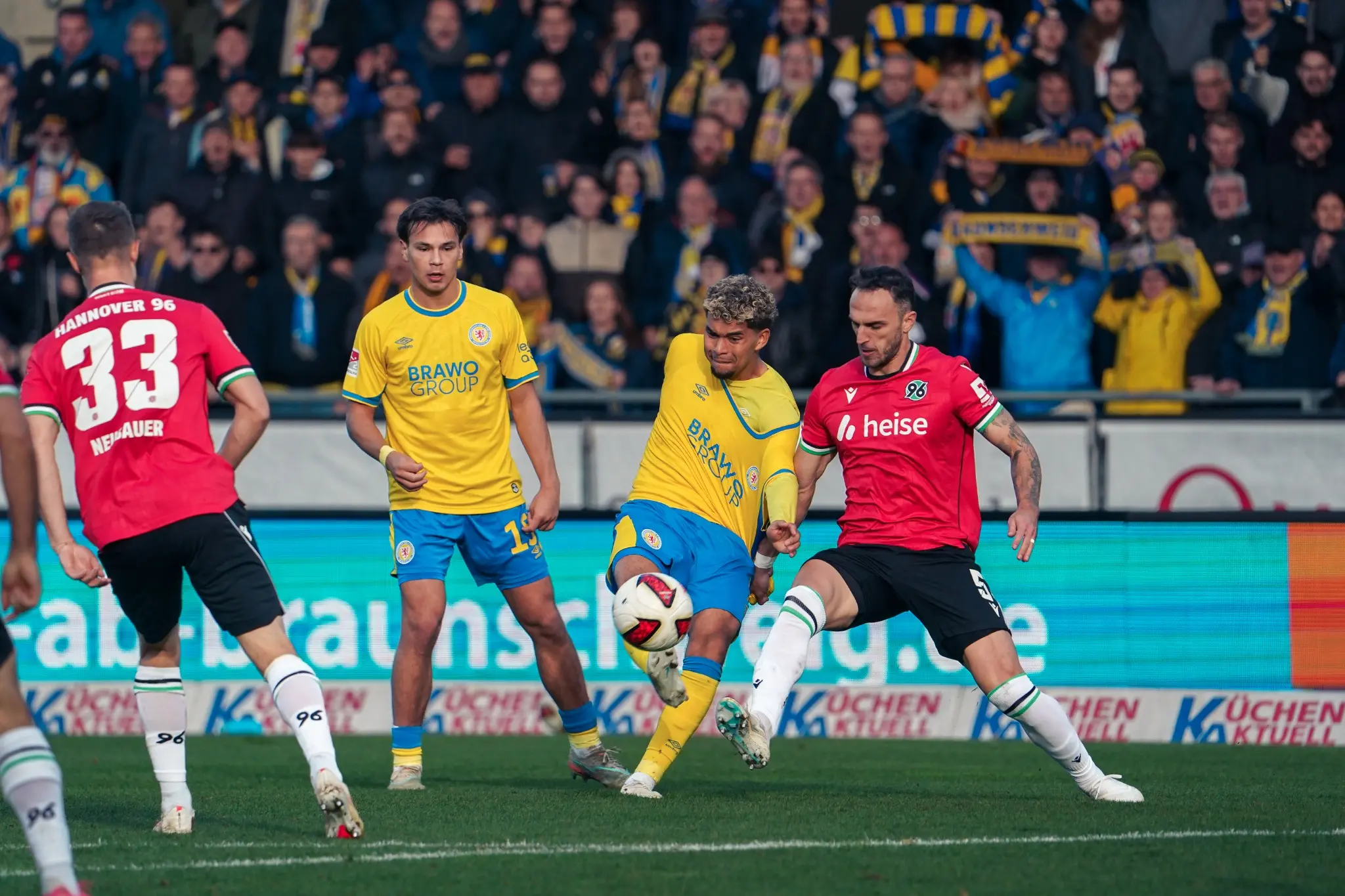 Braunschweig and Hannover players challenge for an aerial ball.