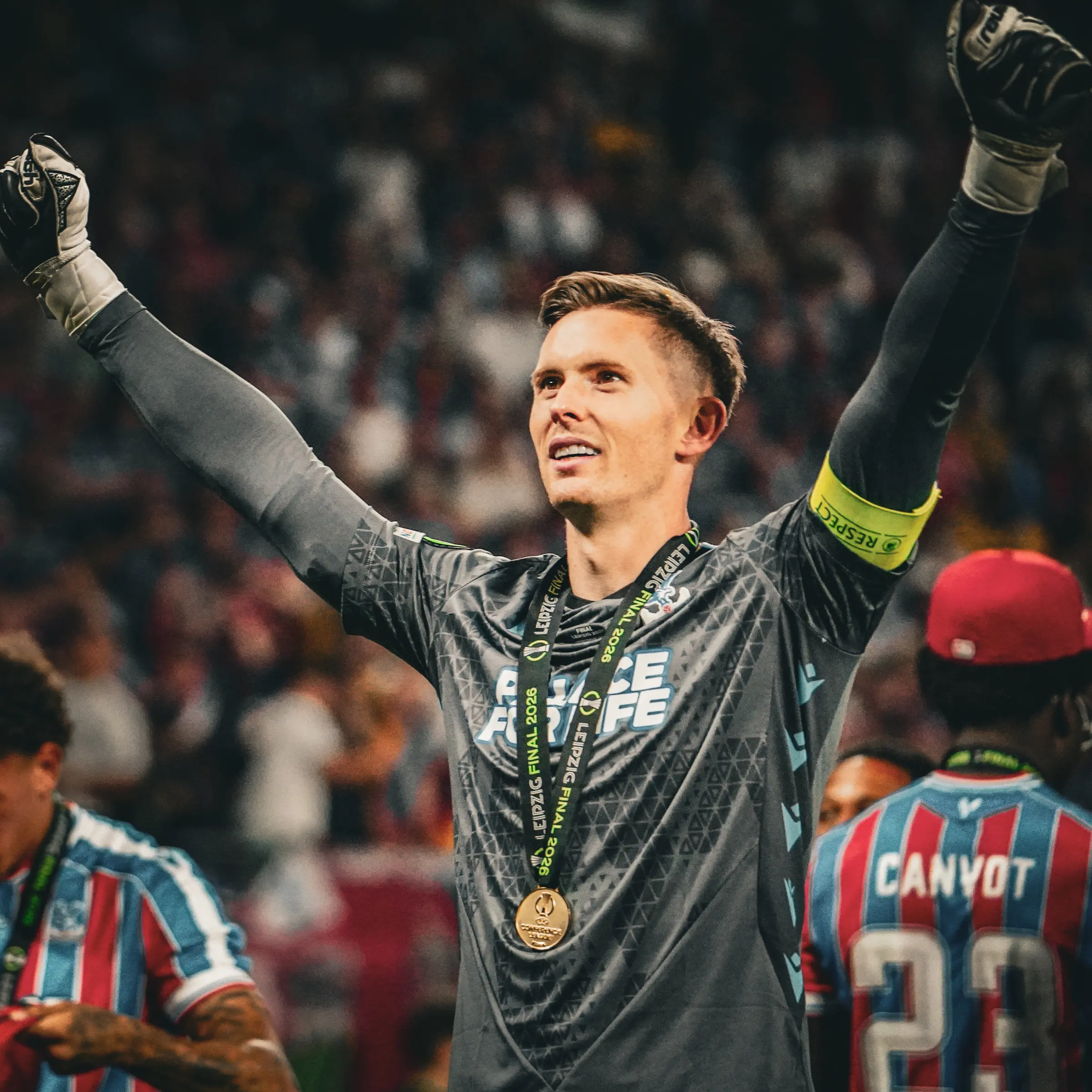 The Crystal Palace goalkeeper raises his arms to the supporters after victory.