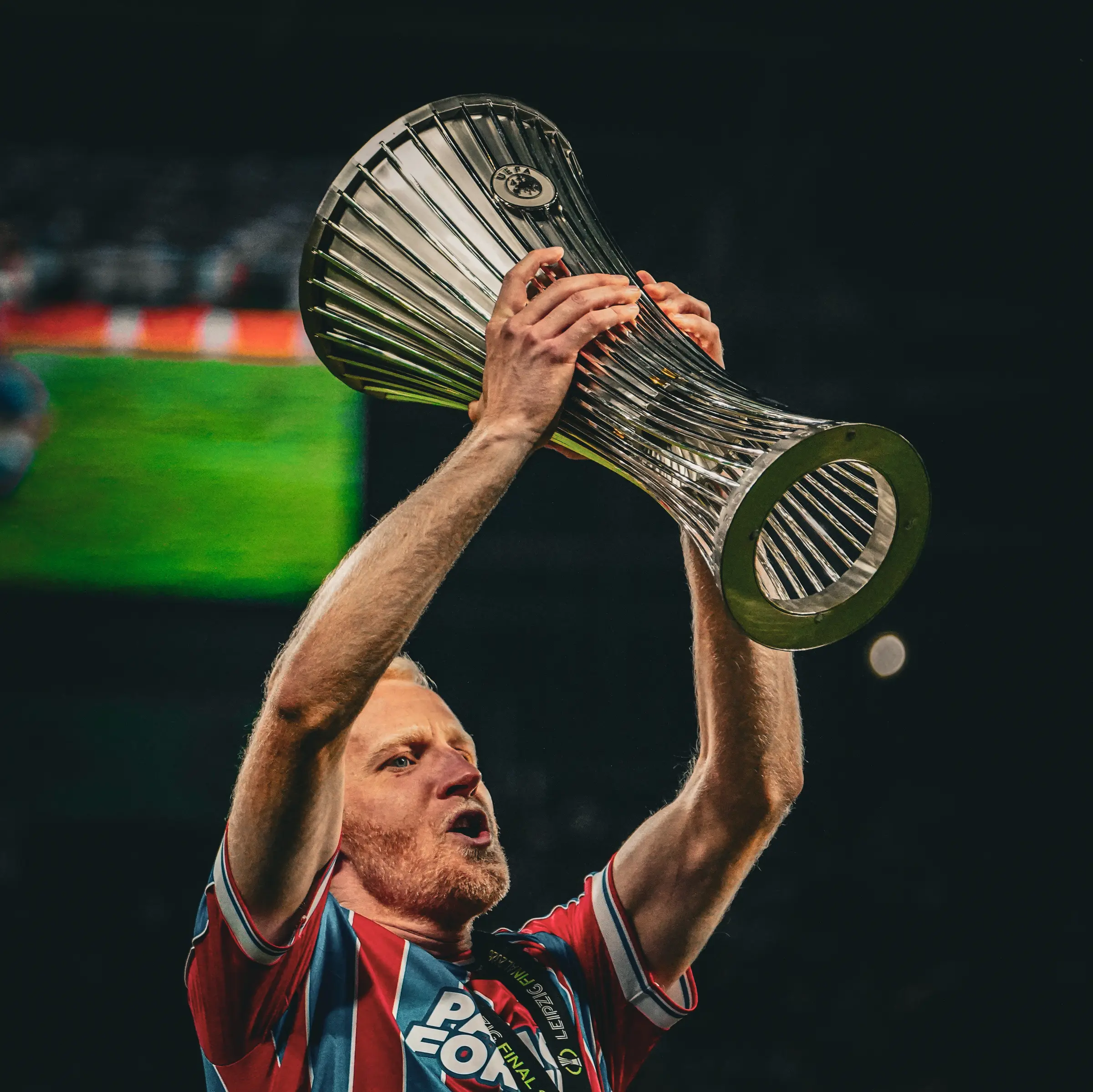 Crystal Palace lift the UEFA Conference League trophy on the winners' stage.