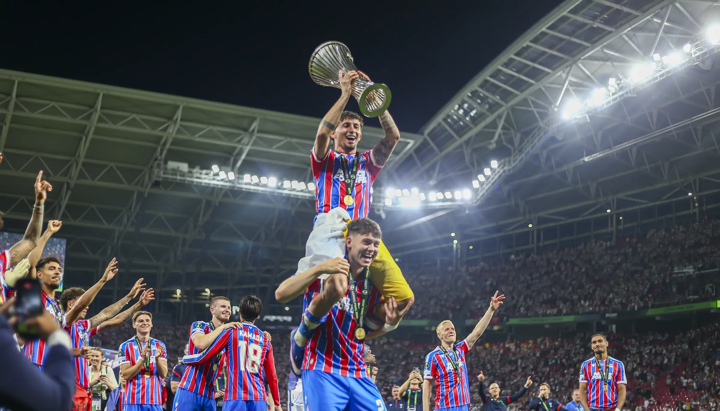 The Conference League trophy is carried above the celebrating Crystal Palace team.