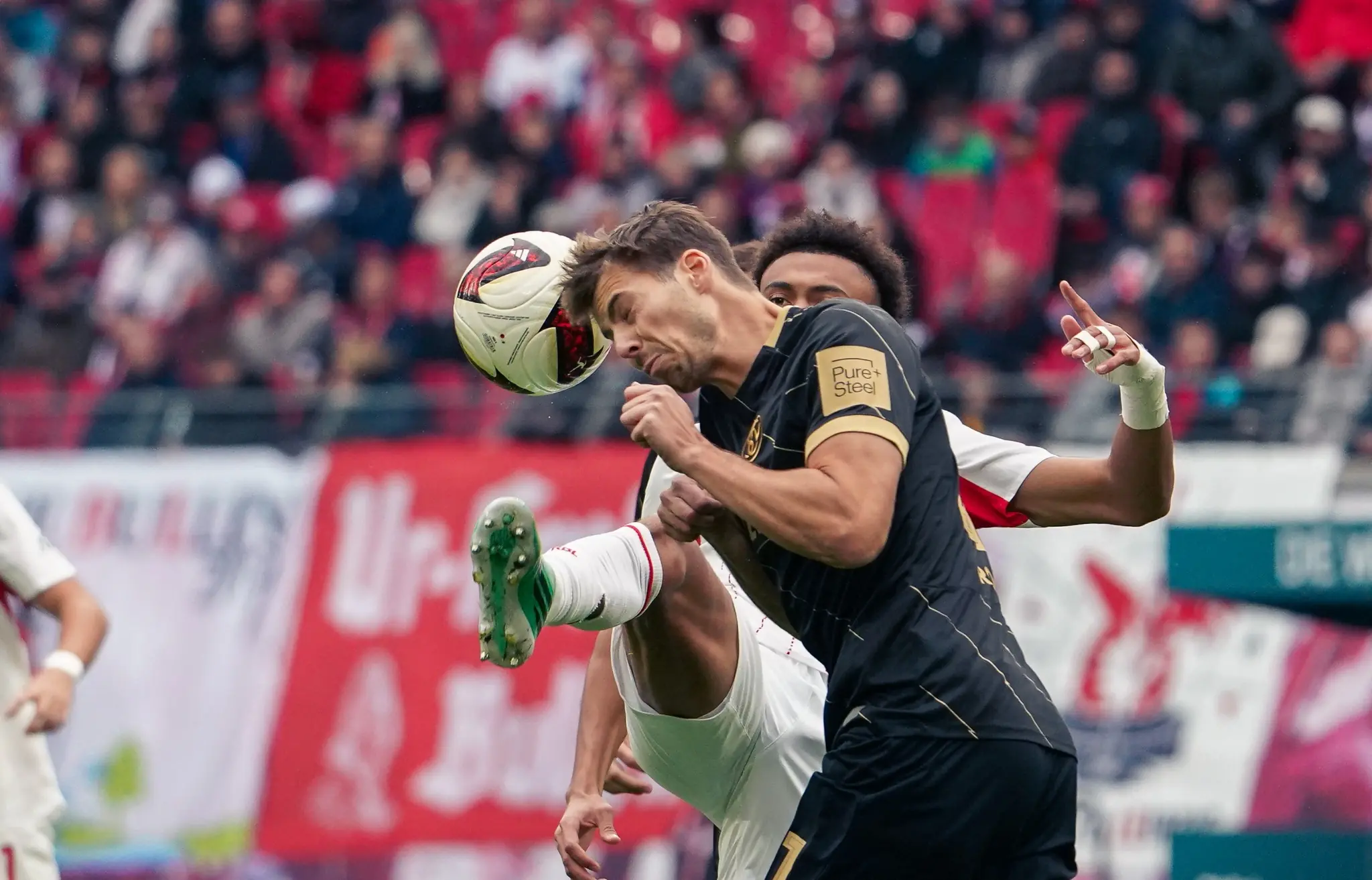 RB Leipzig and SV Elversberg players contest an aerial ball during the Bundesliga match.