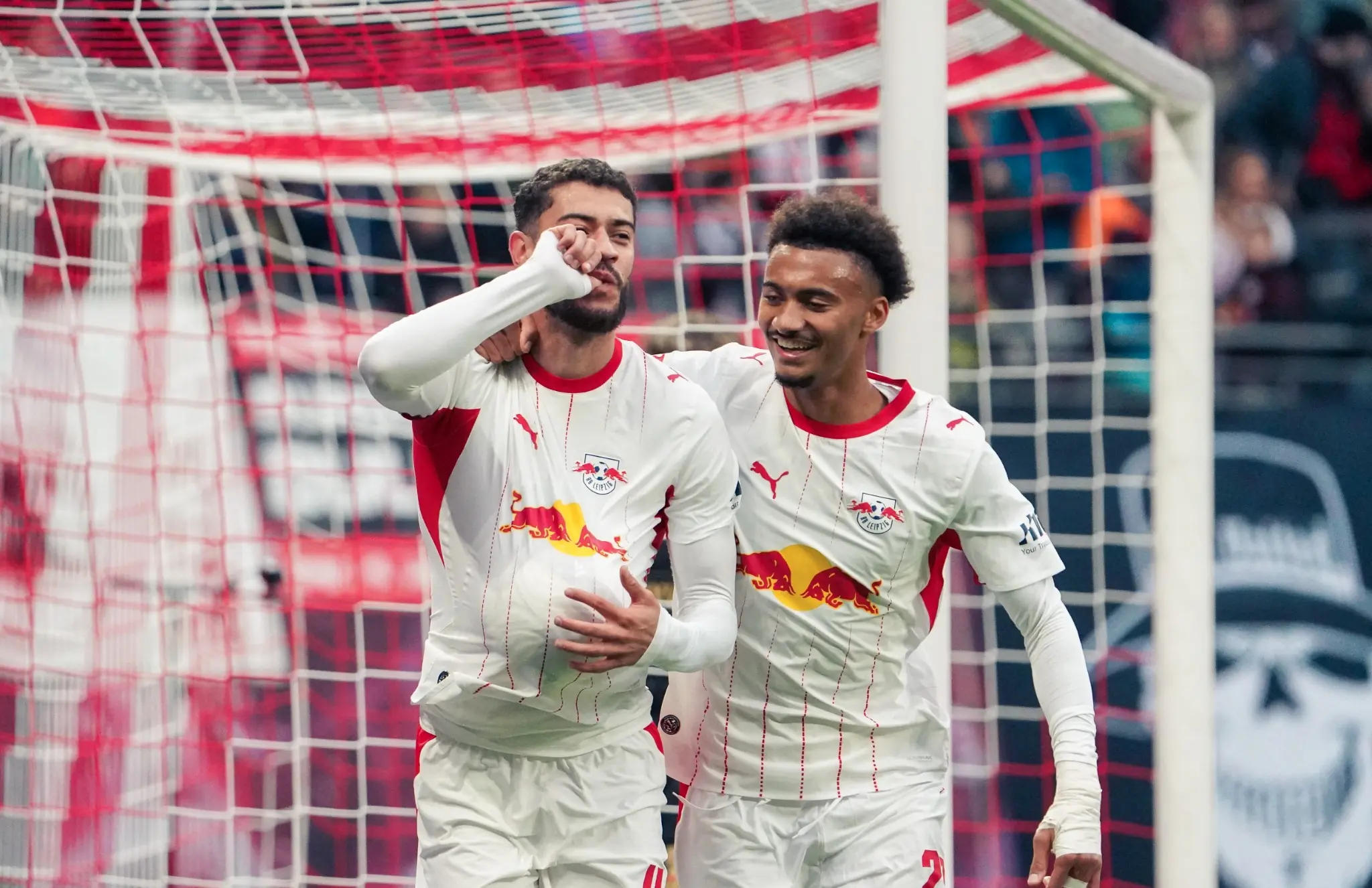 RB Leipzig players celebrate a goal in front of the net against SV Elversberg.
