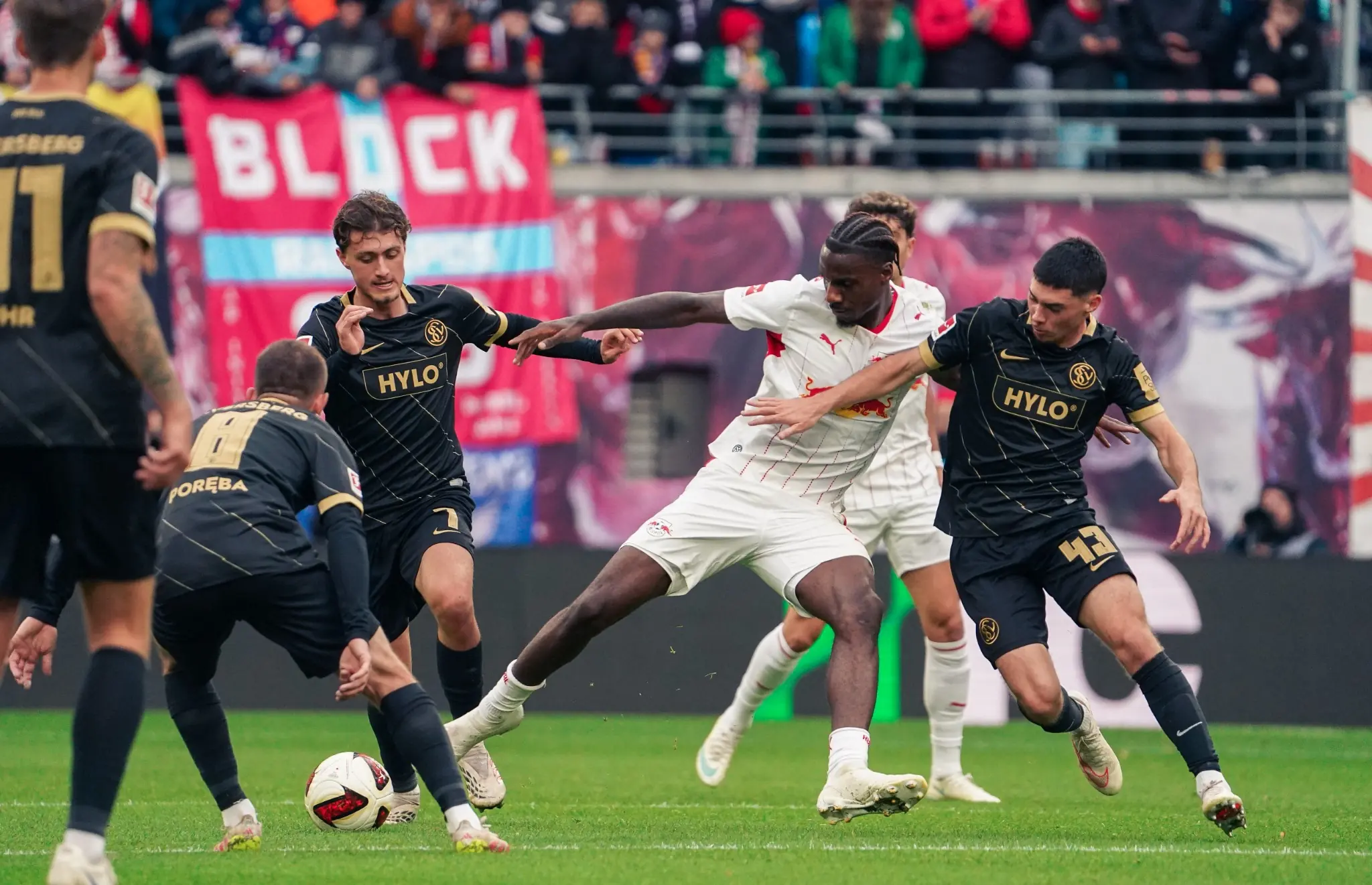 An RB Leipzig attacker battles through several SV Elversberg defenders in the penalty area.