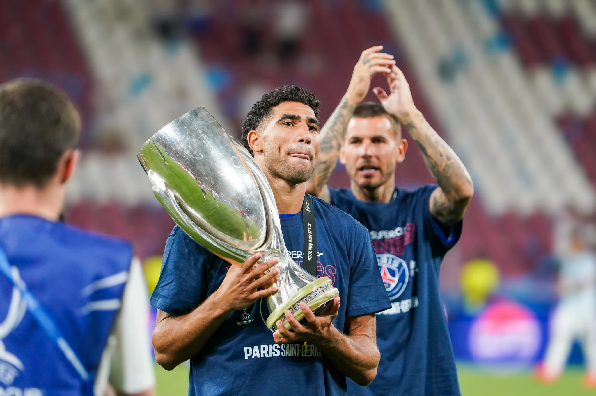 Paris Saint-Germain players celebrate with the UEFA Super Cup trophy.