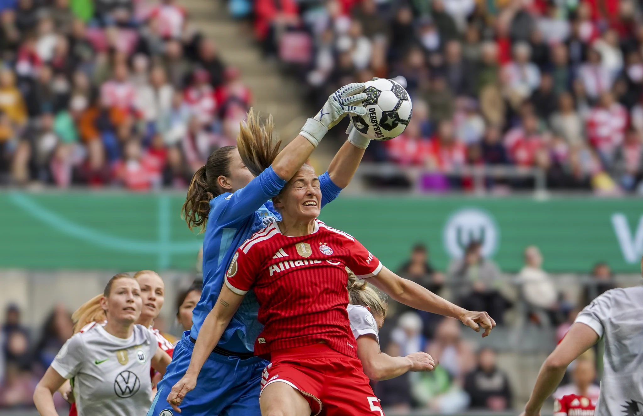 Wolfsburg and Bayern Munich contest the ball in the cup final.