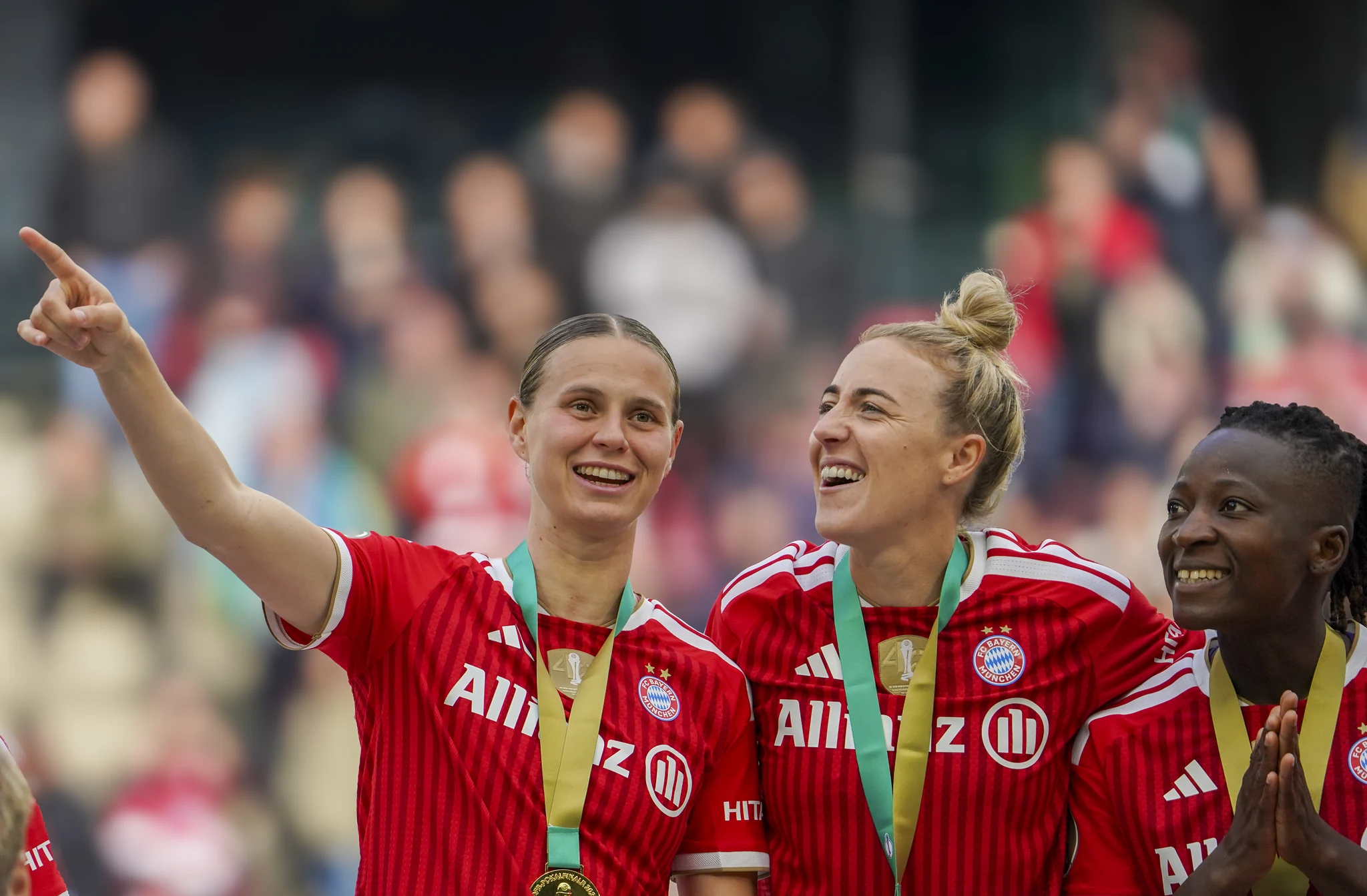 Bayern Munich players smile together wearing their medals.