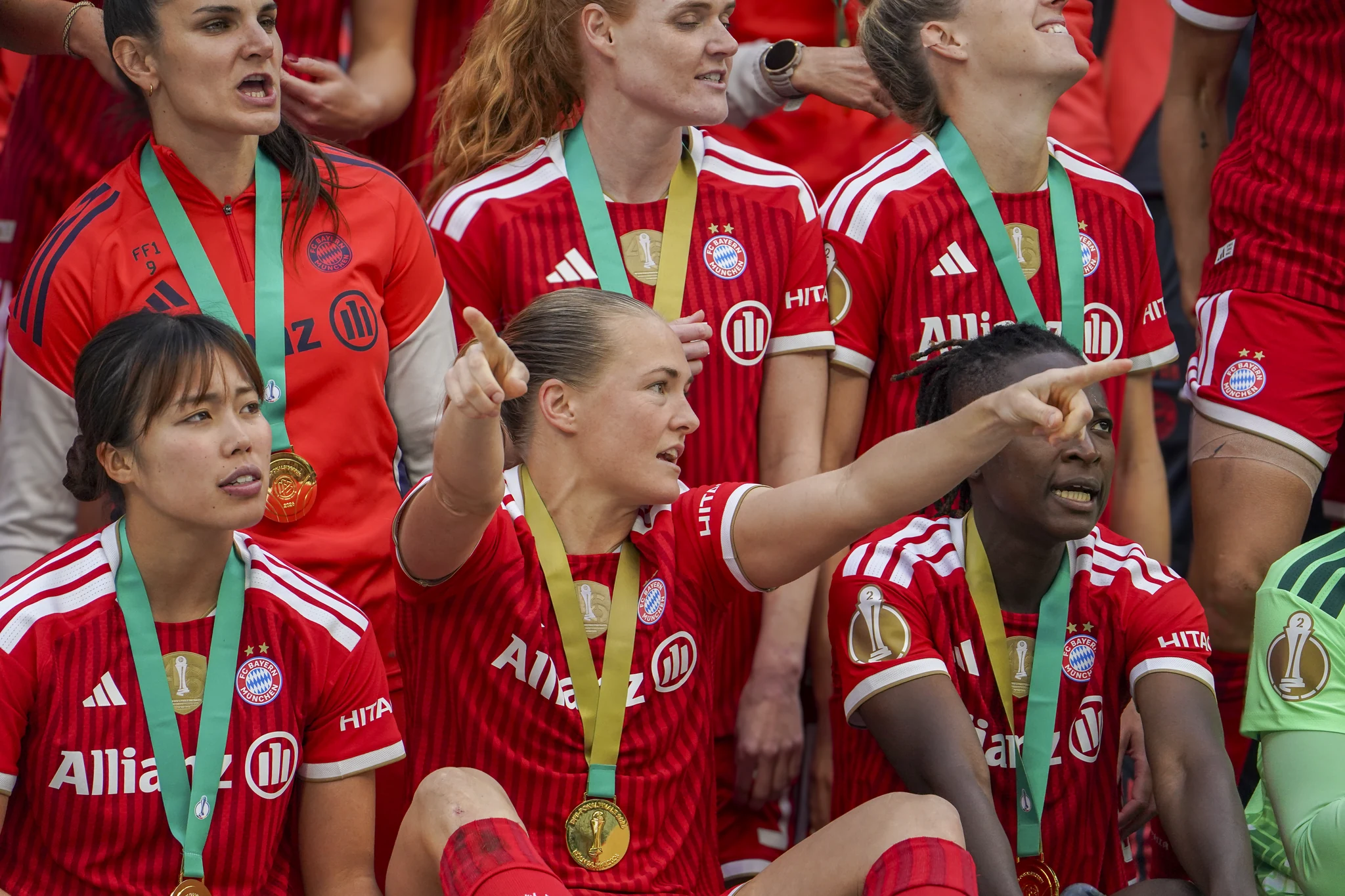 Bayern Munich players smile together around the trophy.