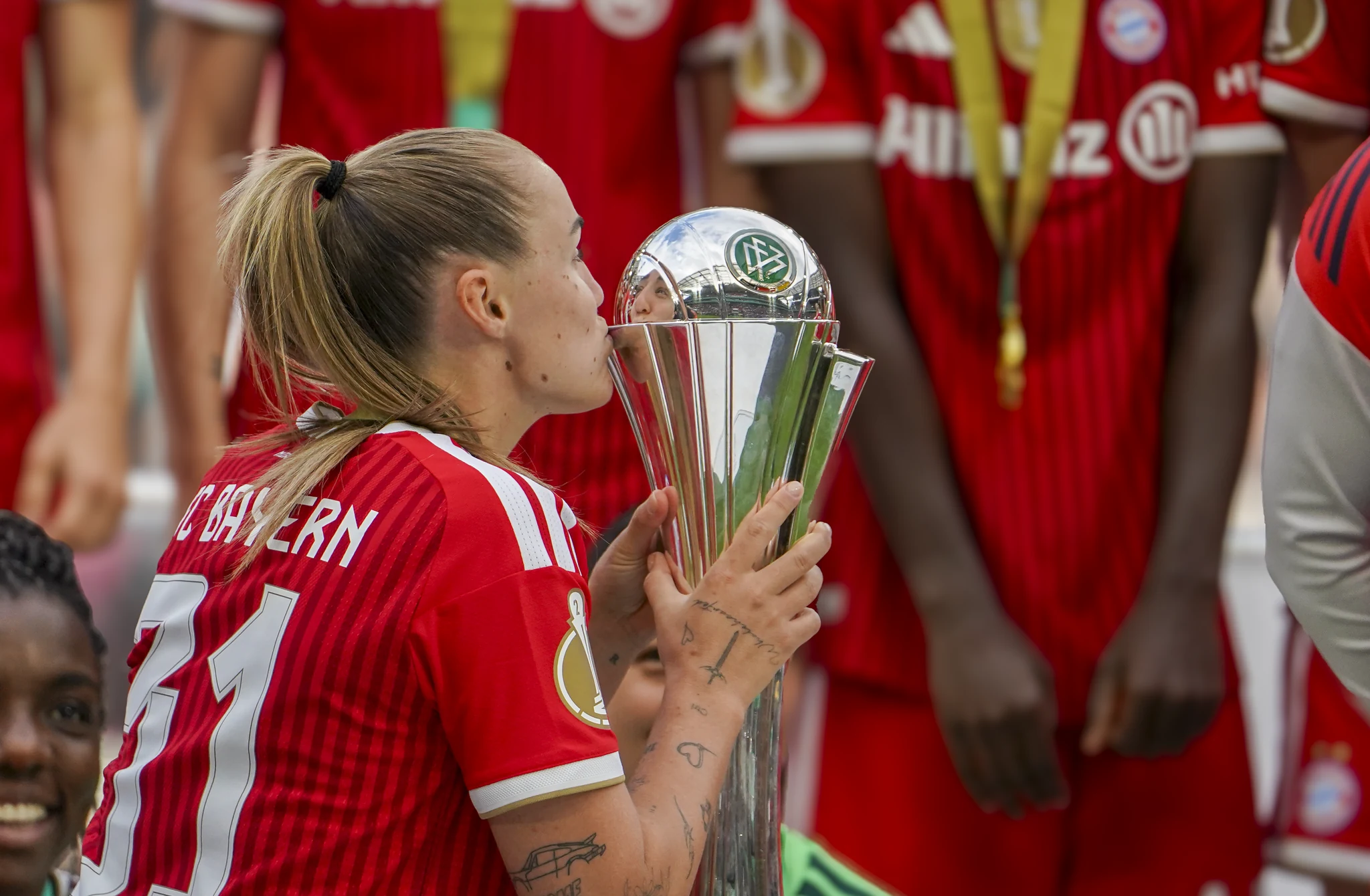 A Bayern Munich player kisses the DFB-Pokal trophy.