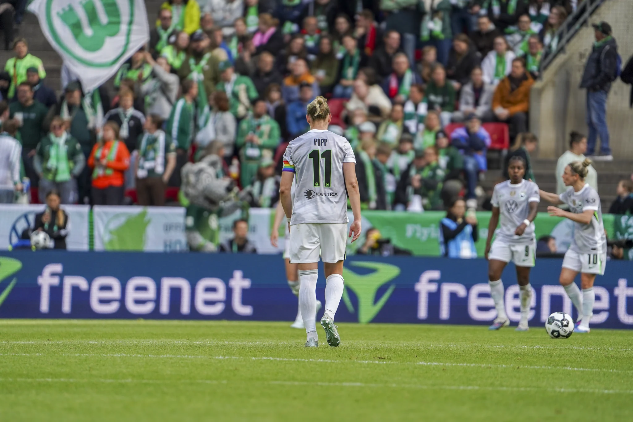 Wolfsburg players stand in front of their supporters.
