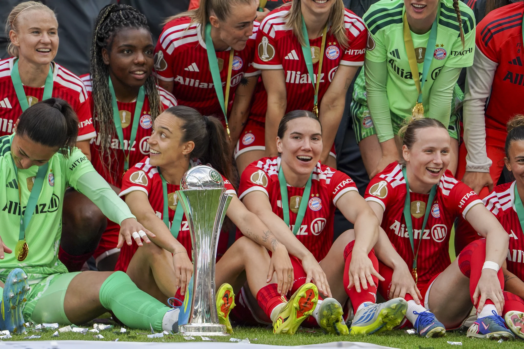Bayern Munich players smile together around the trophy.